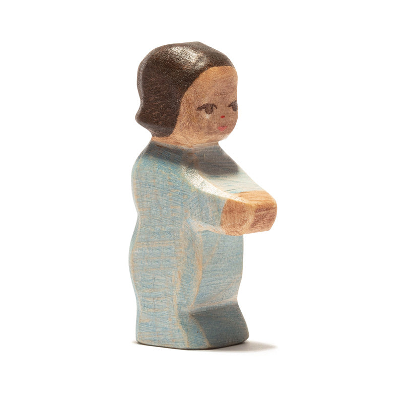Toddler with brown hair and a medium brown skin tone in blue onesie by Ostheimer