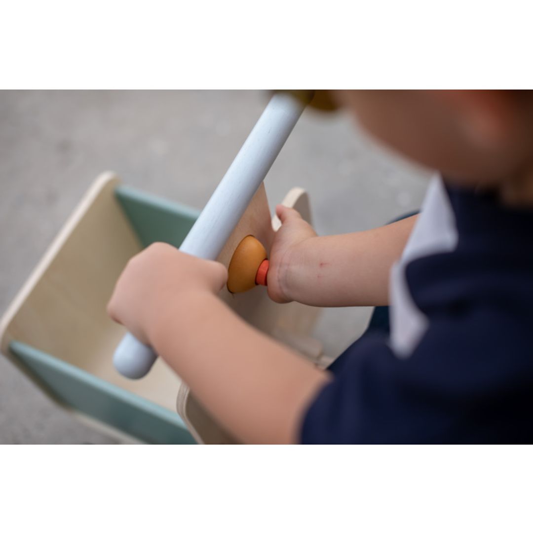 Child playing with a Delivery Bike in Orchard by plan toys