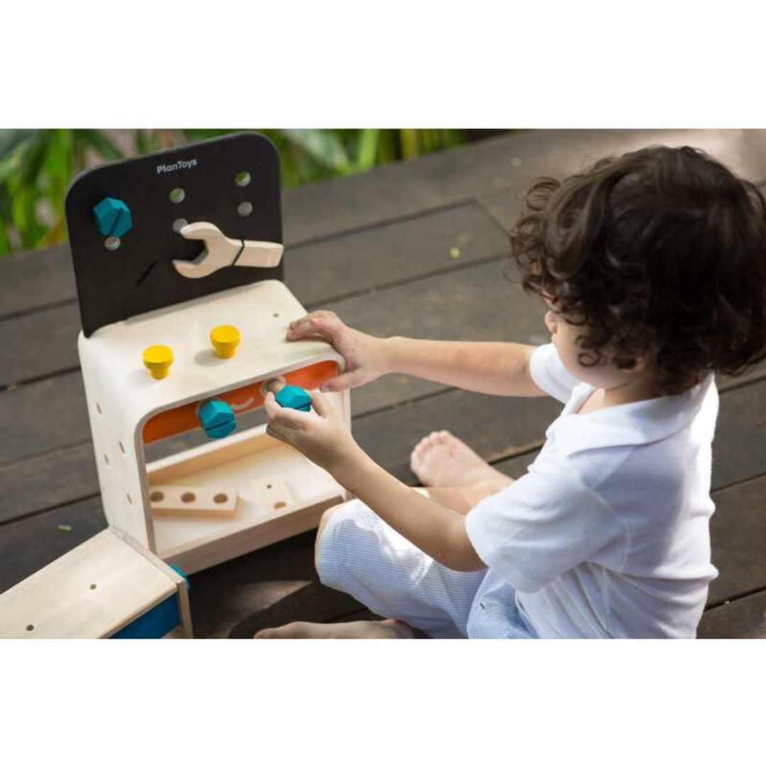 Child Playing with a Workbench by Plan Toys