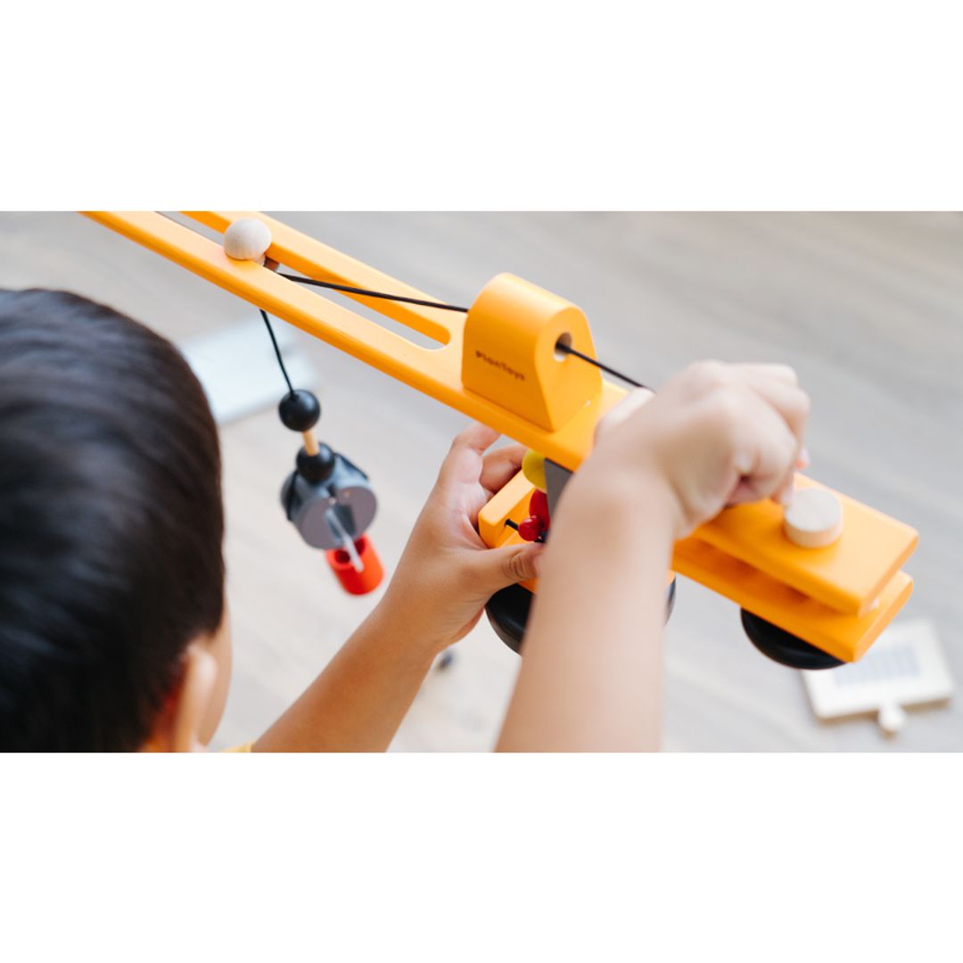 Child playing with Plan Toys Crane Set