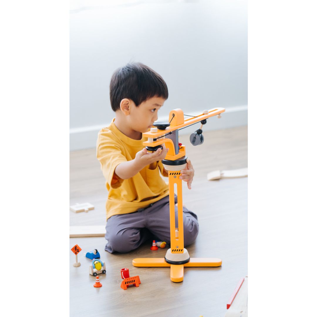 Child playing with Plan Toys Crane Set