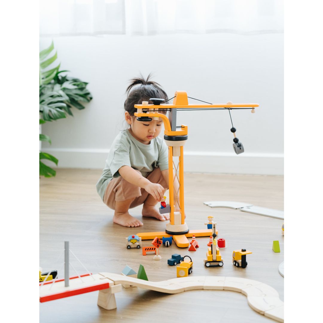 Child playing with Plan Toys Crane Set