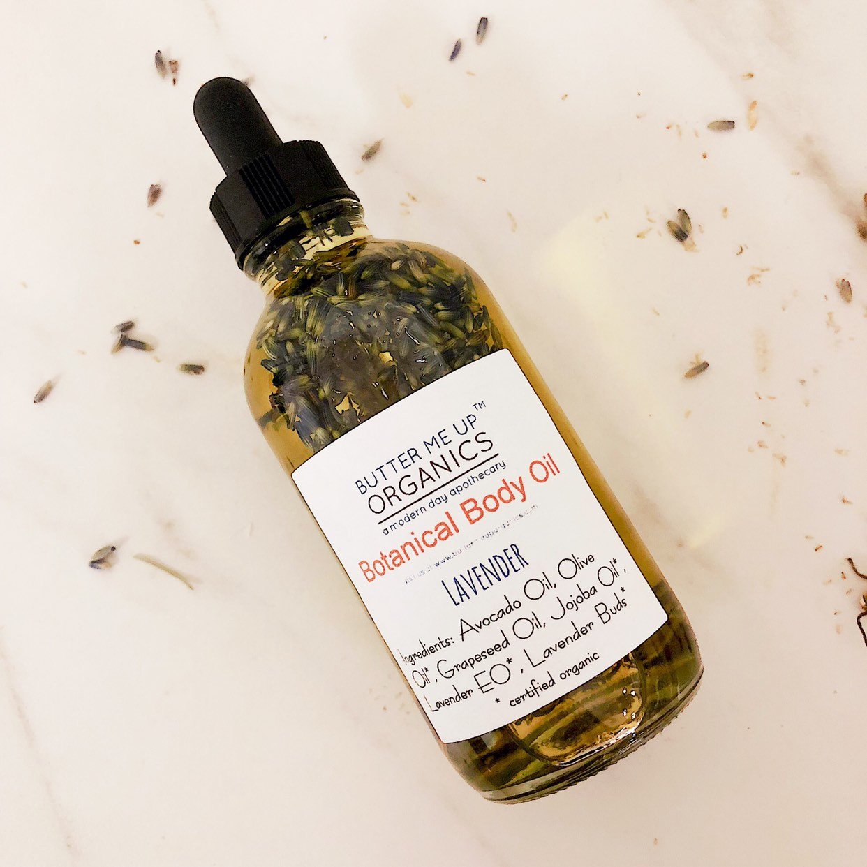 Butter Me Up Organics botanical body oil bottle on a light background