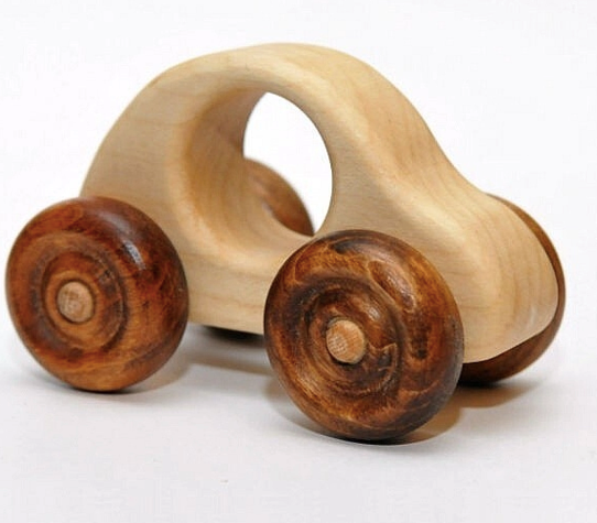 Wooden toy car with natural finish on a white background