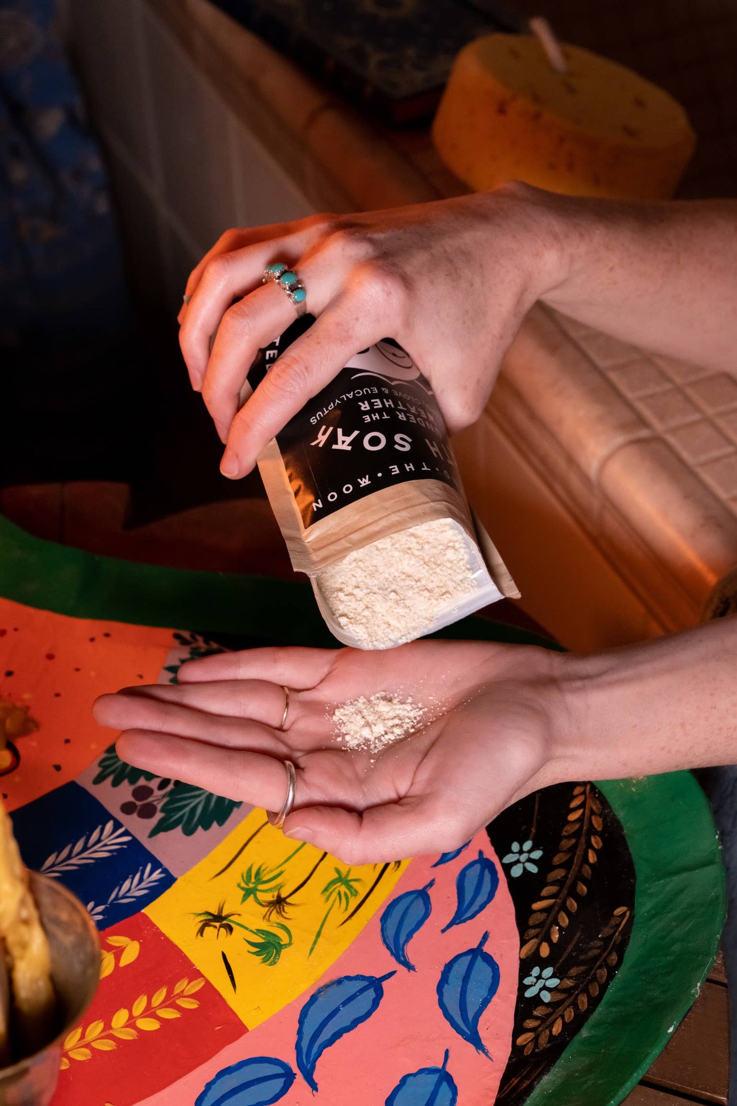 a person pouring soothe bath soak from its bag into their hand