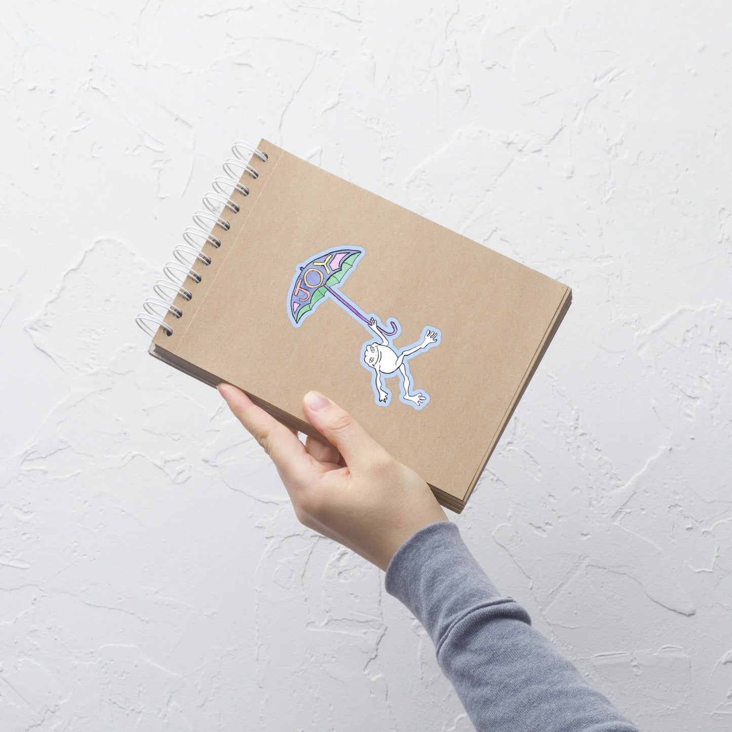 blue joy frog sticker on a flip notebook