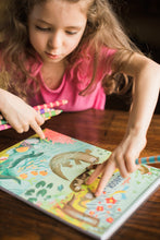 Load image into Gallery viewer, child wearing a pink shirt sitting at a table with an otters sketchbook
