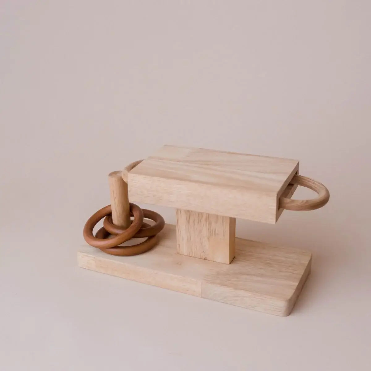 Wooden rings activity toy on a beige background