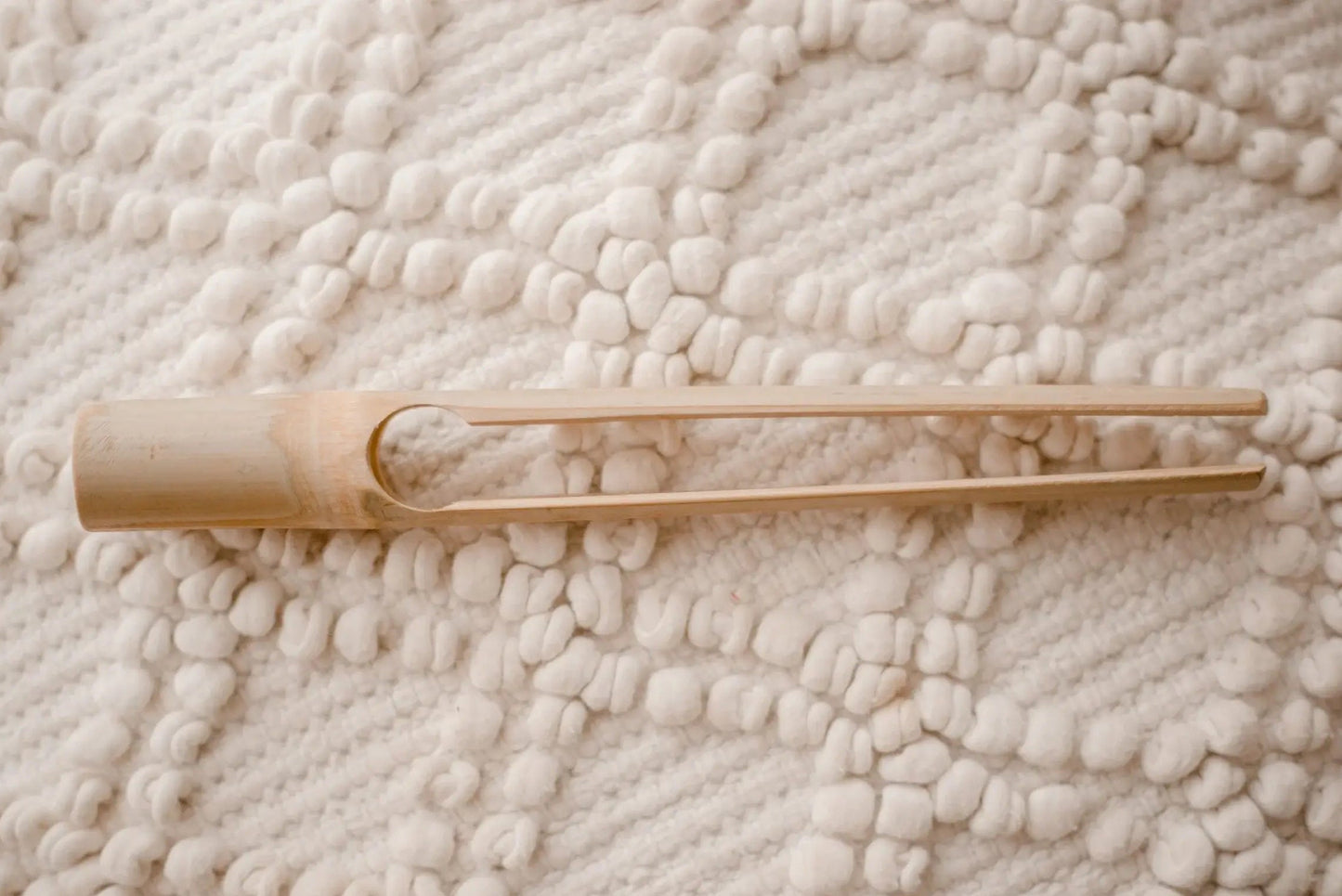 bamboo tongs on a textured beige blanket