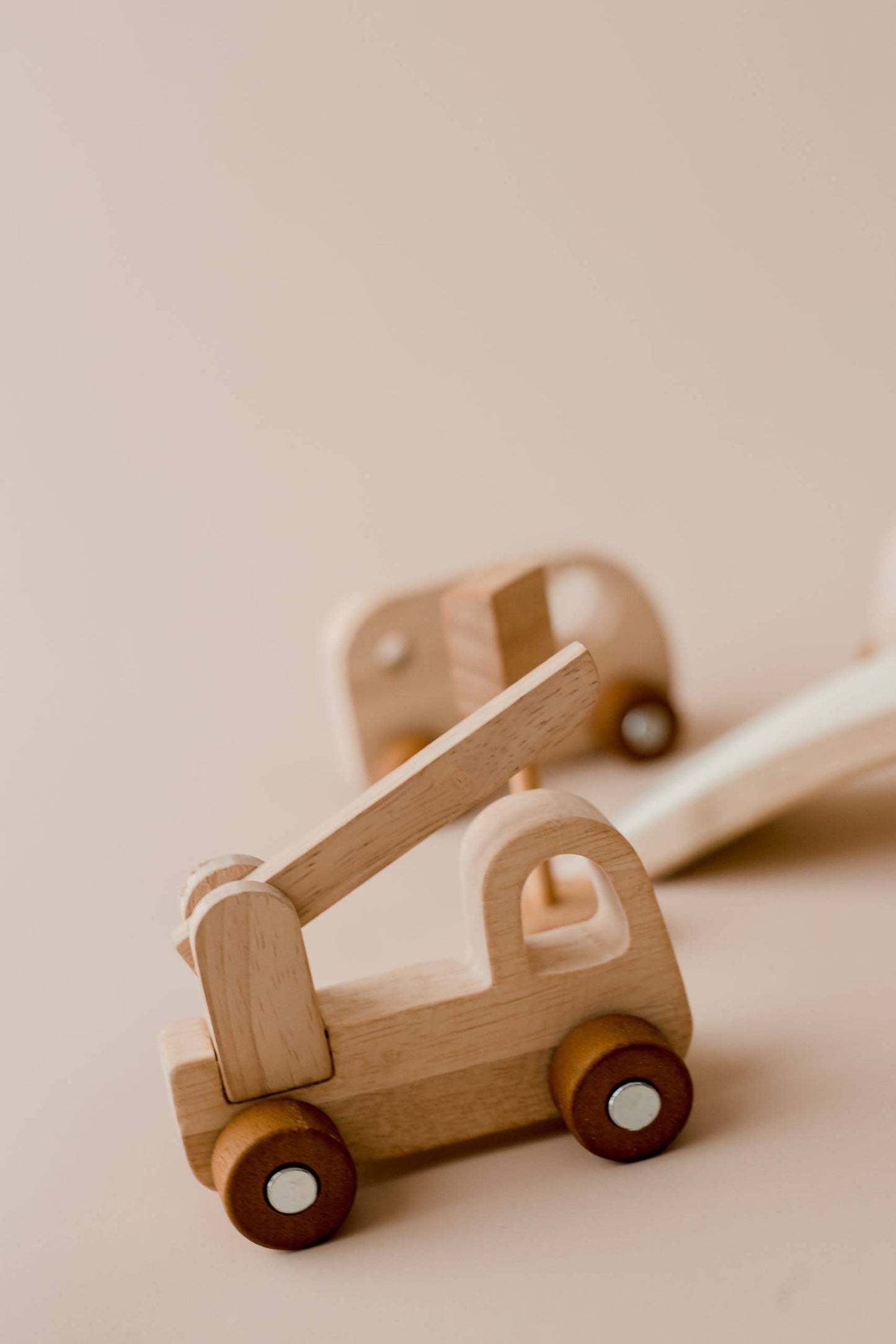 Wooden toy crane truck on a beige background