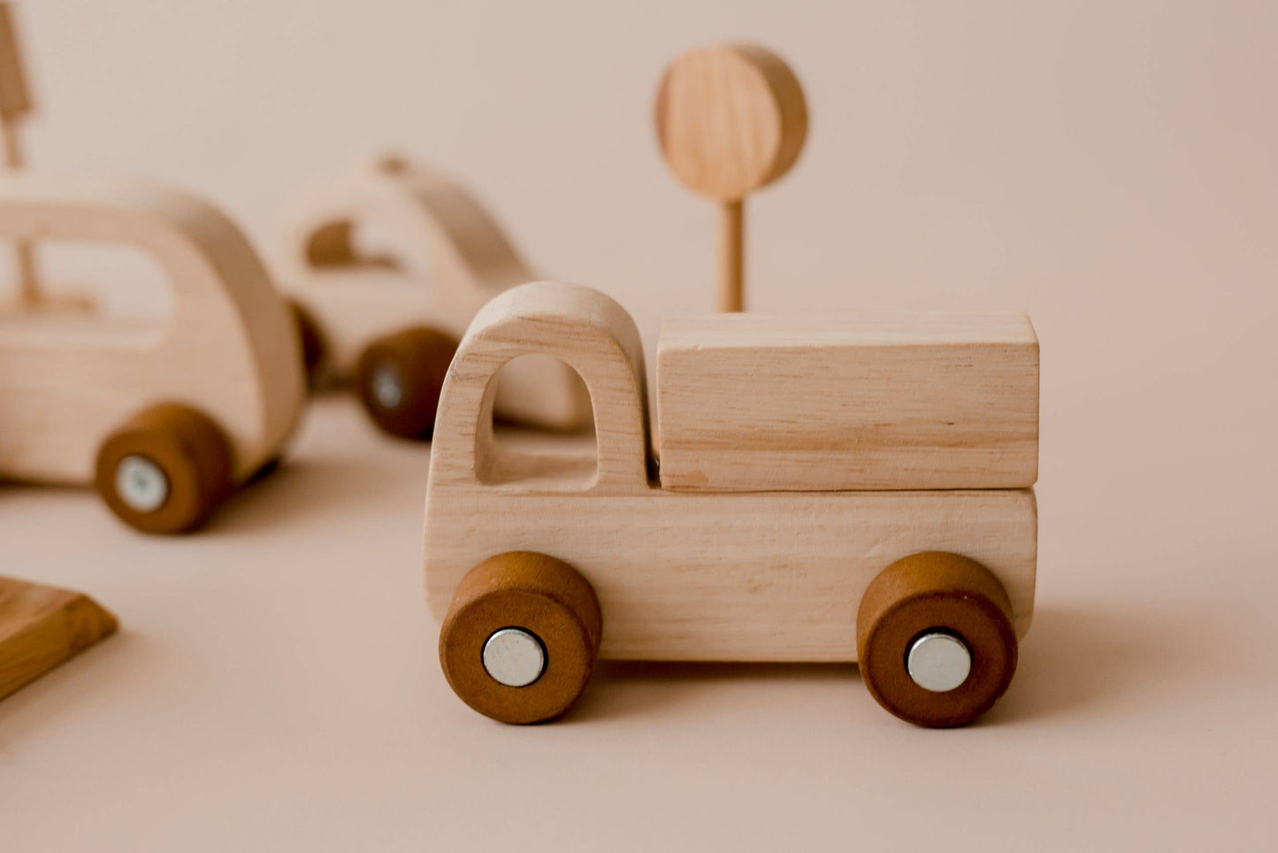 Wooden toy truck and road sign on a beige background