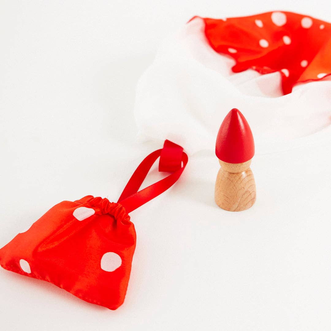 Red polka dot bag for mushroom parachute with a wooden peg gnome on a white background