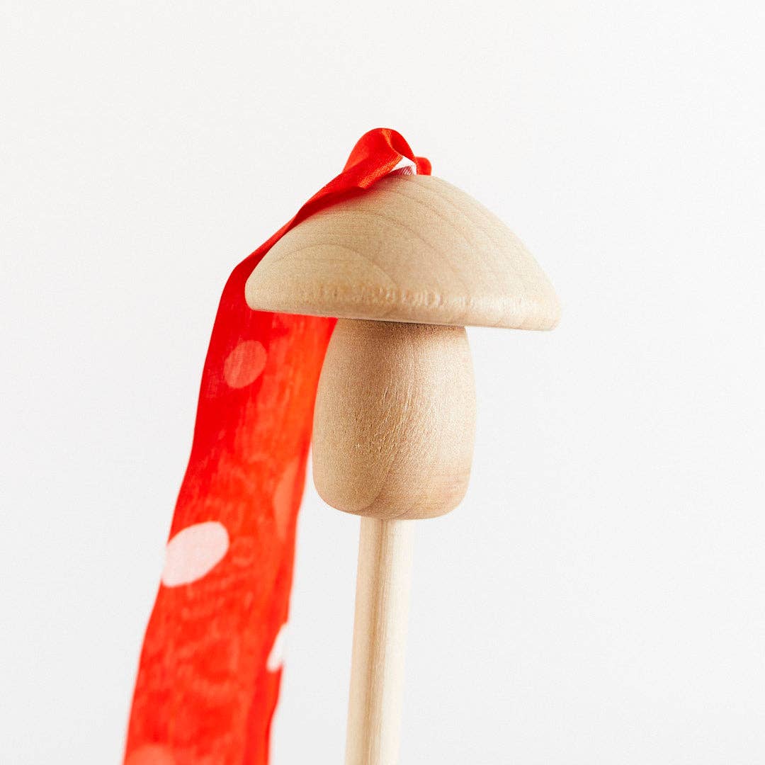 Wooden mushroom top detail for red mushroom streamer wand on a white background