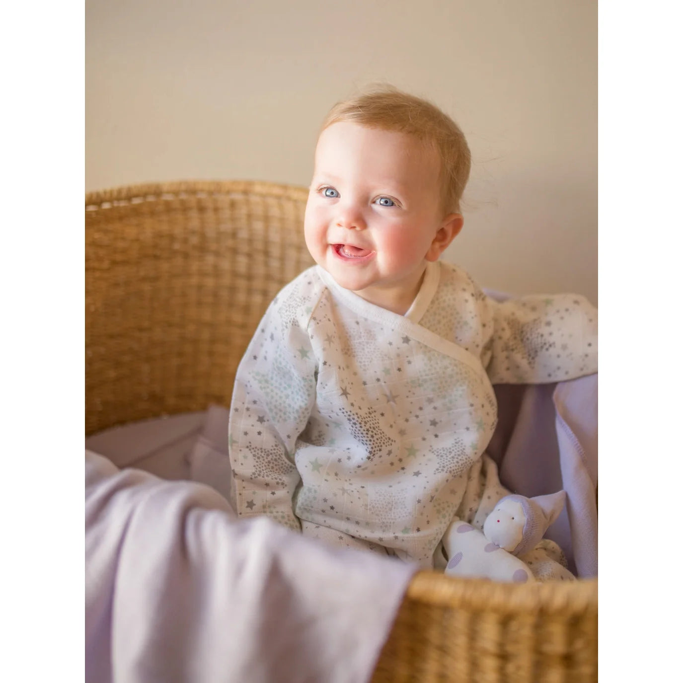 Baby sitting in under the nile's Muslin Side Snap Star Wrap Kimono