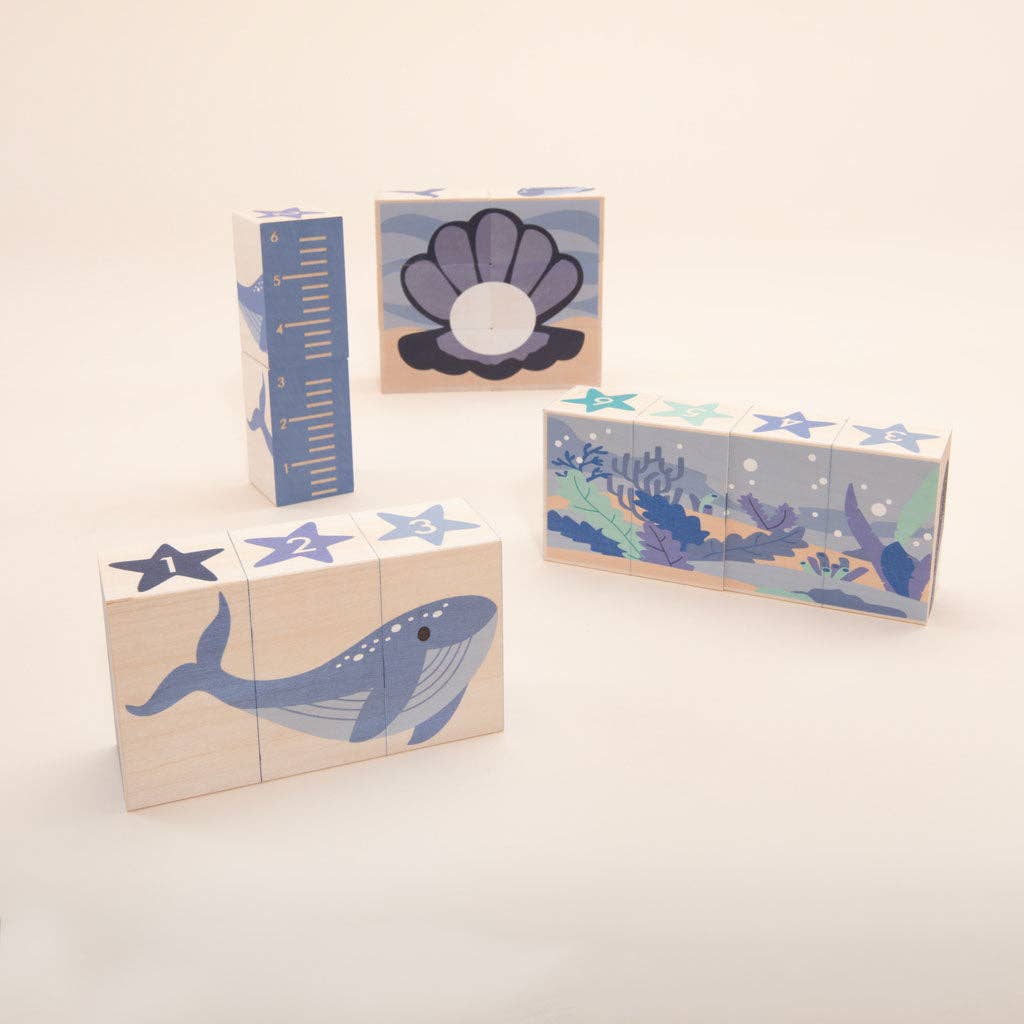 Set of wooden blocks with ocean-themed designs on a light beige background