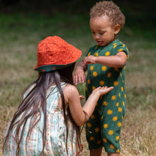 Load image into Gallery viewer, Two children playing outside in a grass field, one wearing Cherries Reversible Sunhat in Olive
