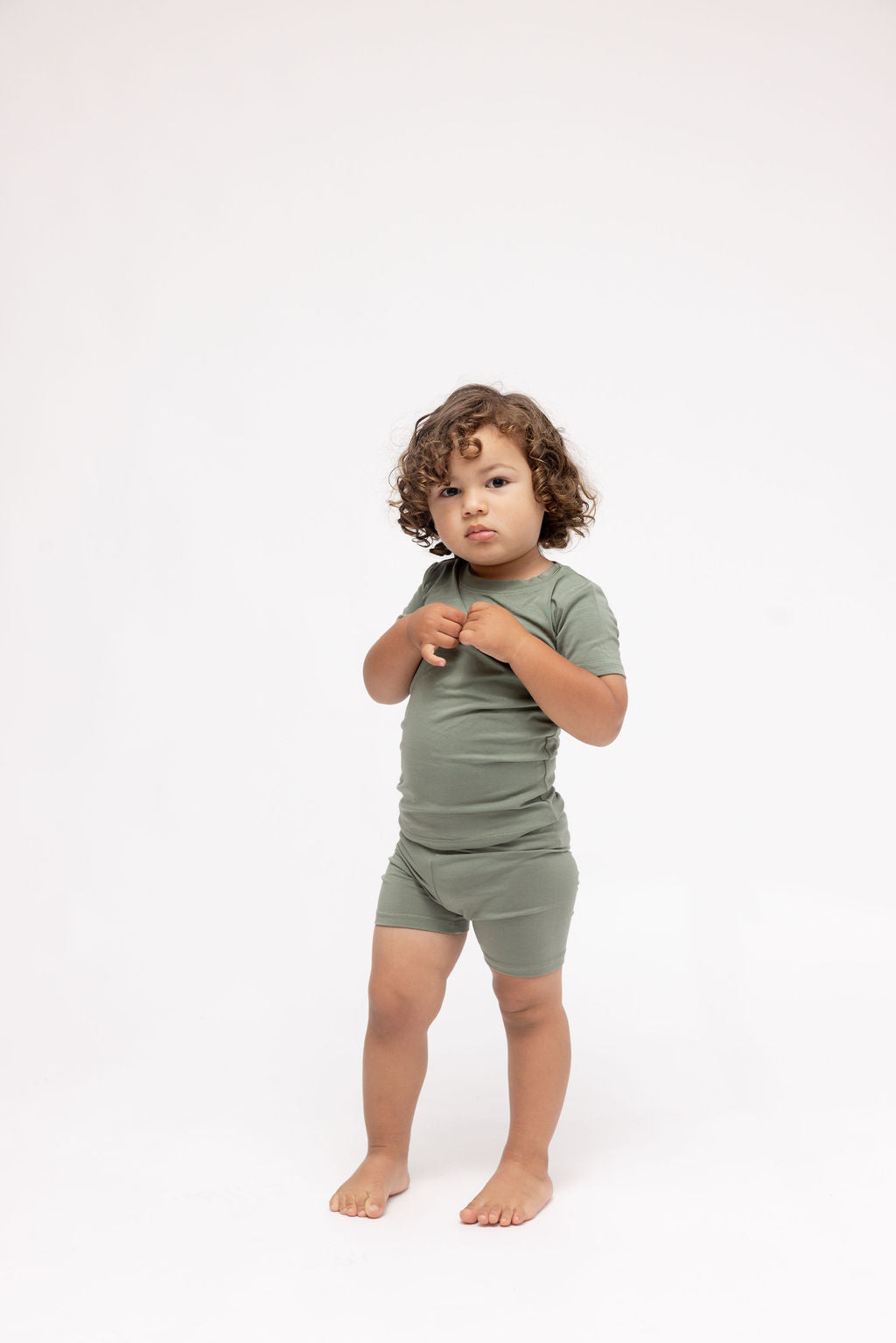 Child wearing a green outfit on a white background
