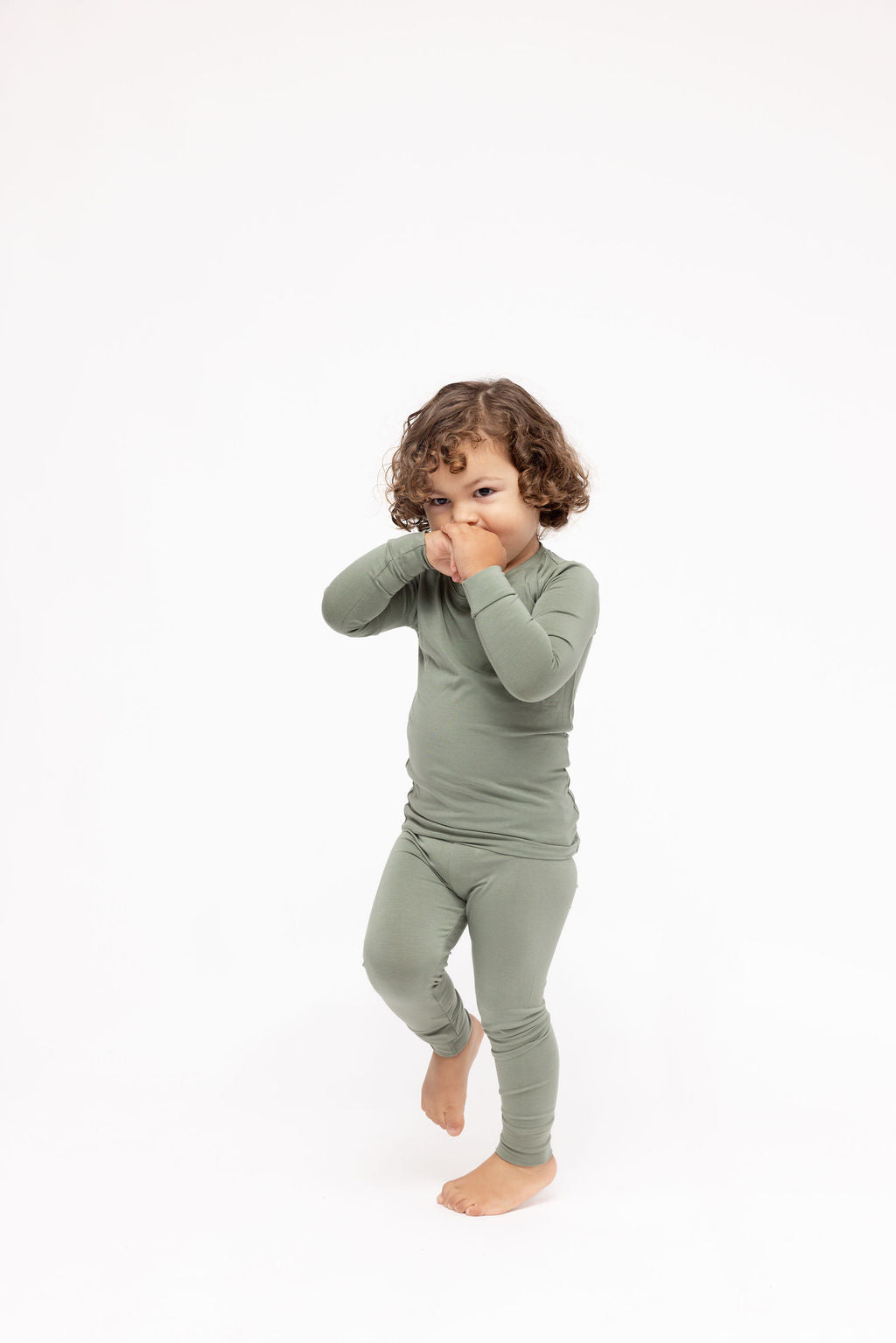 Child wearing a green outfit on a white background