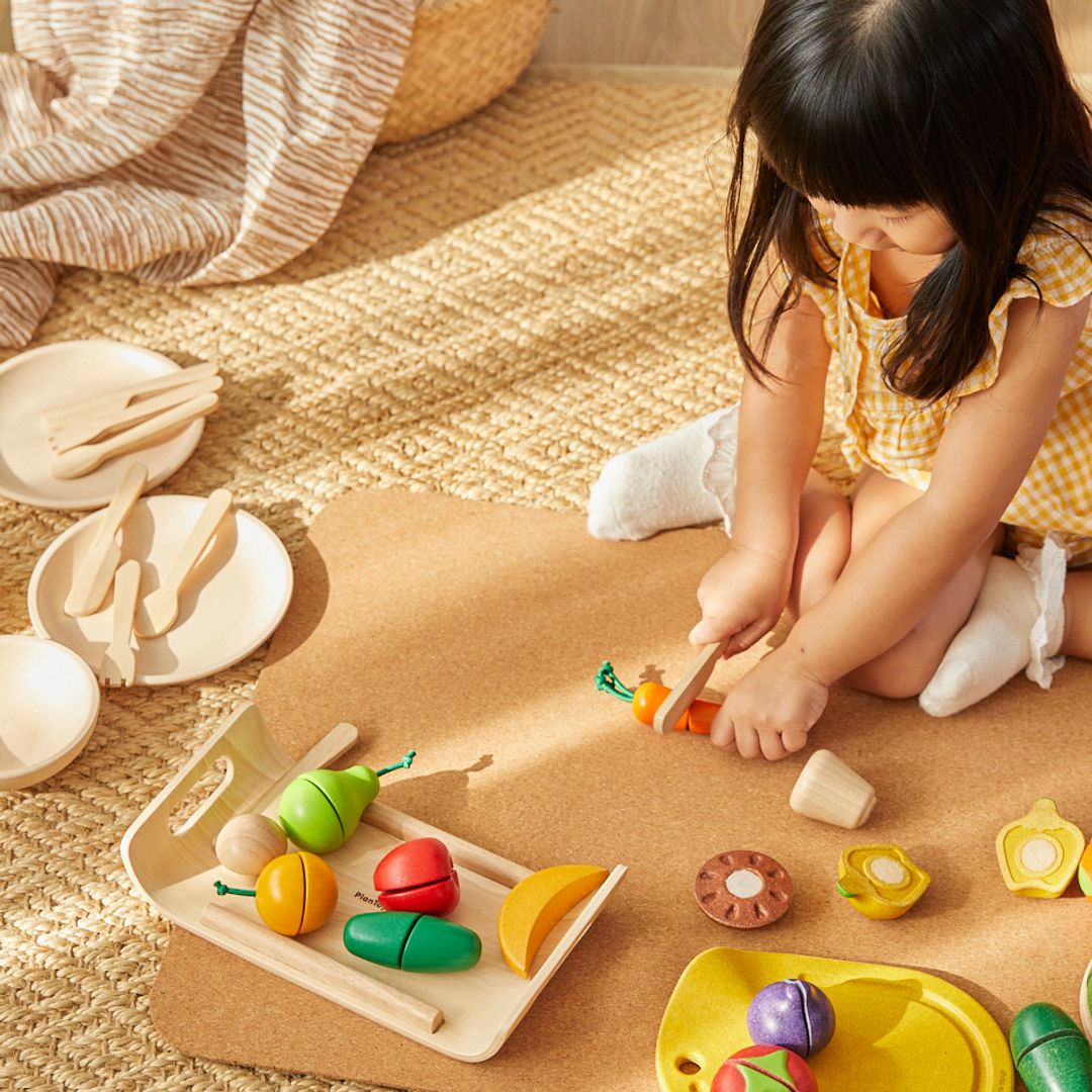 Child playing with colorful wooden toys on a mat