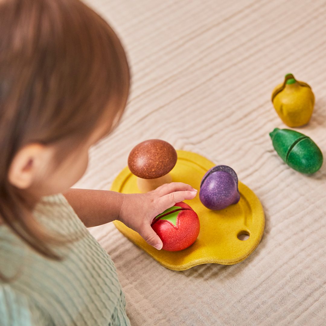 Child playing with colorful wooden toys on a light surface