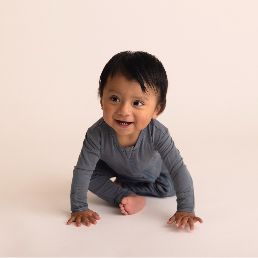 Child in a gray long-sleeve shirt on a plain background