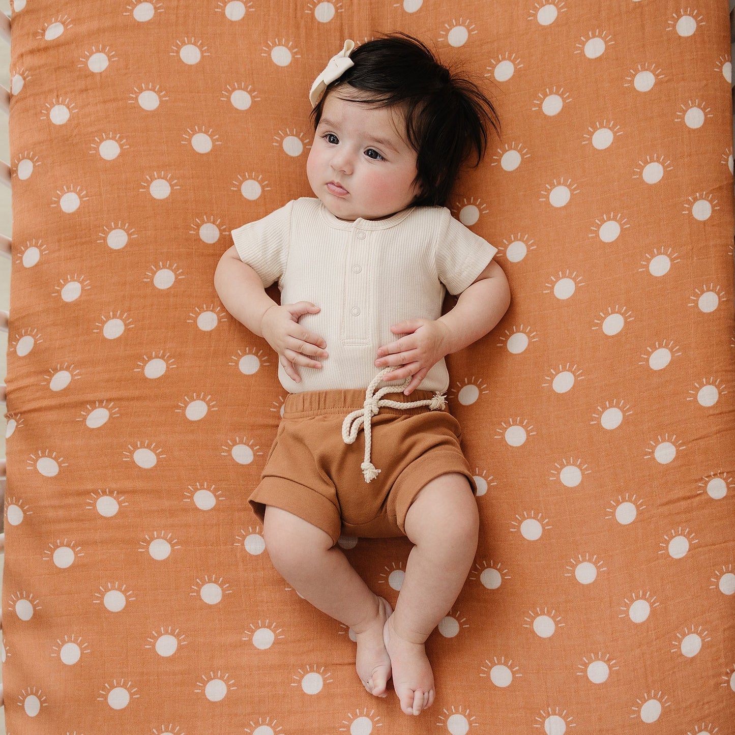 Child sitting on a patterned orange surface