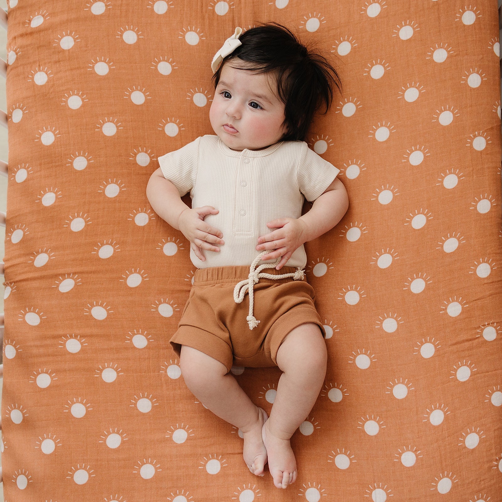 Child sitting on a patterned orange surface