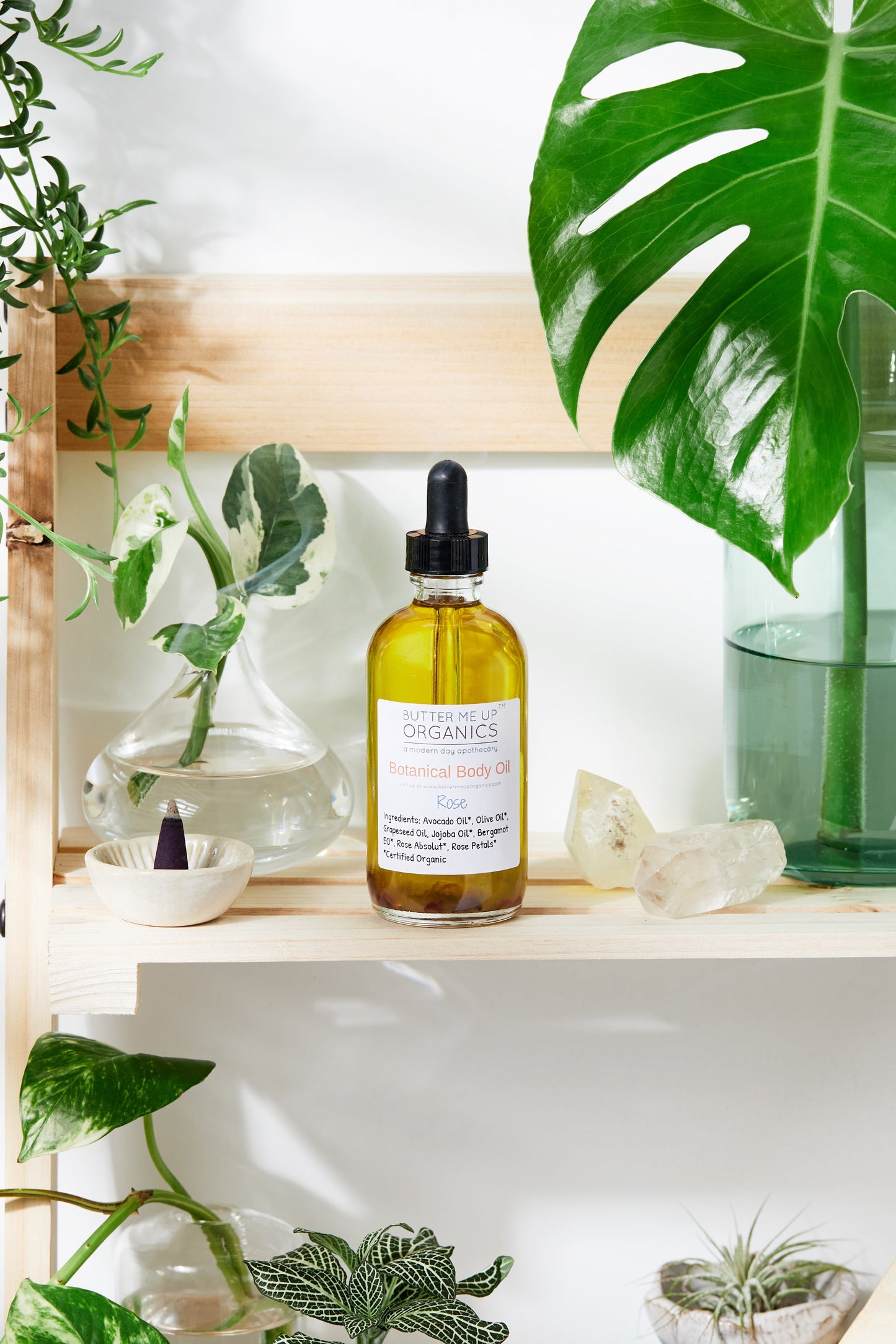 Bottle of organic hair oil on a shelf with plants in the background