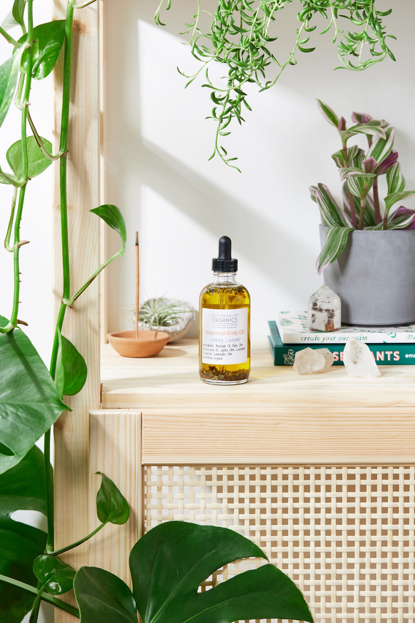 Bottle of oil on a wooden shelf with plants in the background