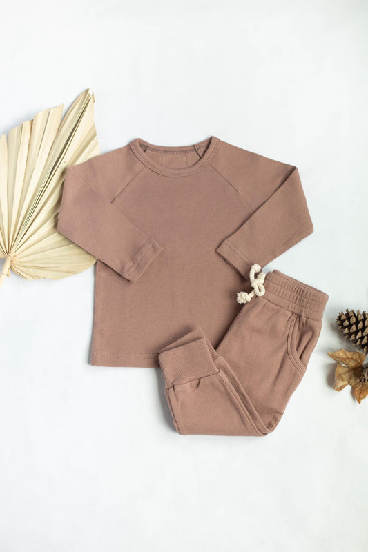 Brown sweatshirt and pants set with decorative elements on a white background