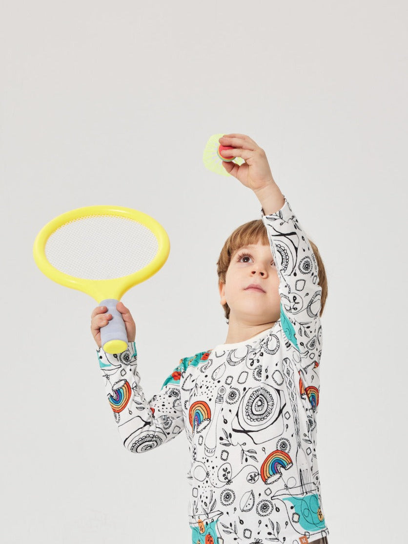 Child playing with a yellow ring toy against a light gray background