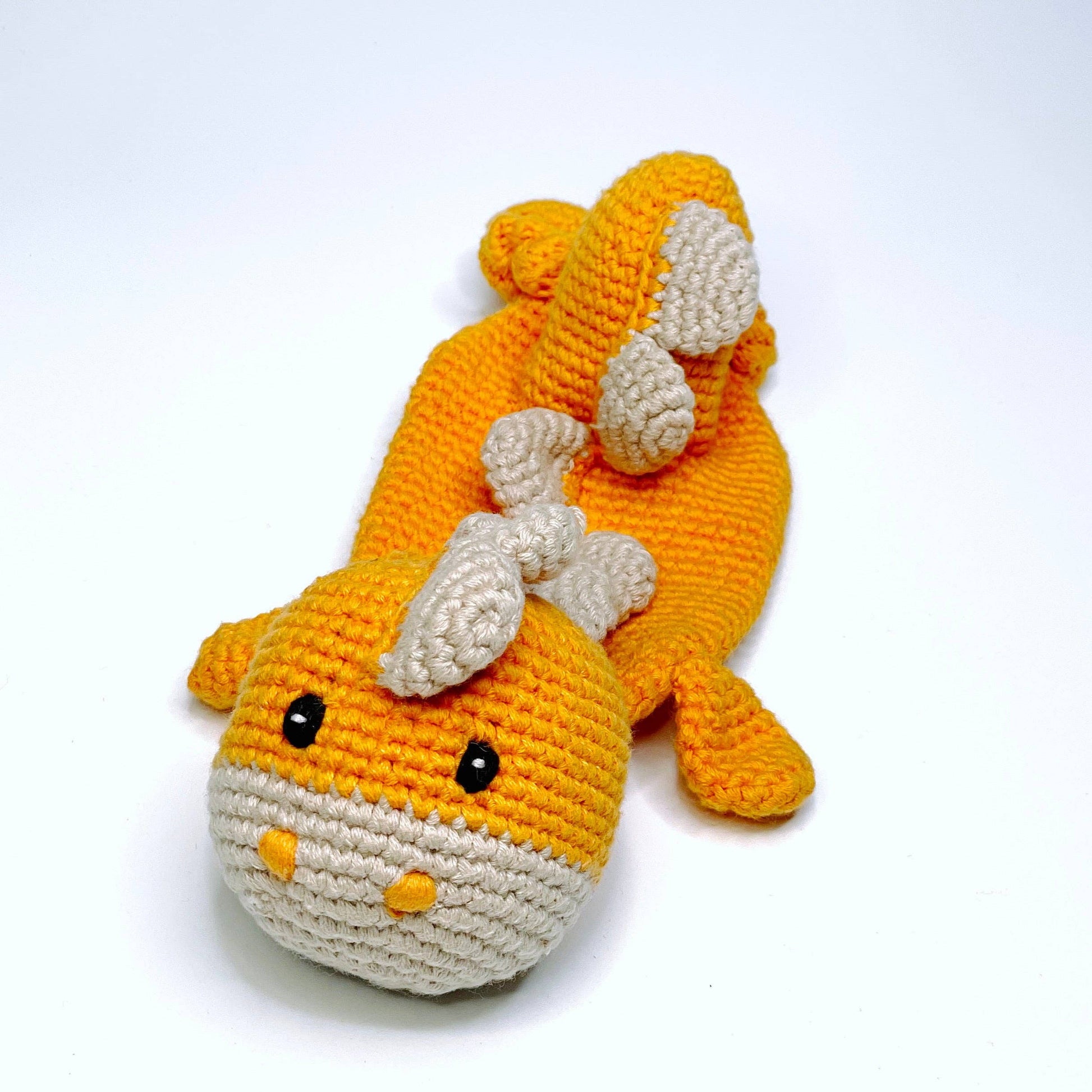 Crocheted dinosaur toy on a white background