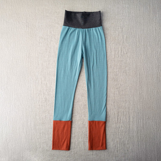 Color-blocked leggings with blue, gray, and red on a textured gray background