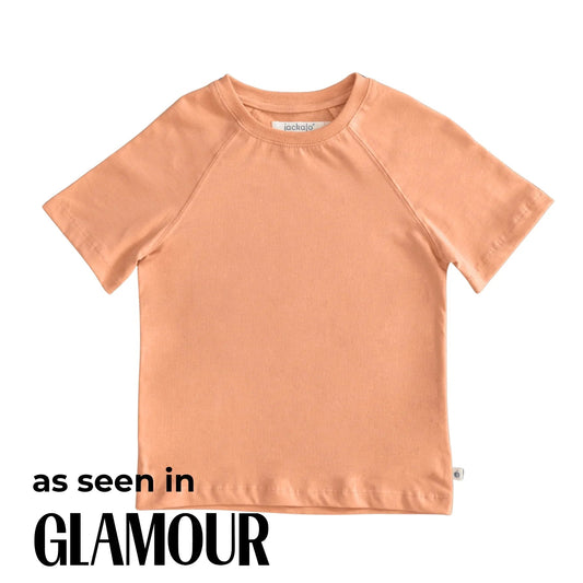 Peach-colored t-shirt on a white background with 'as seen in Glamour' text.