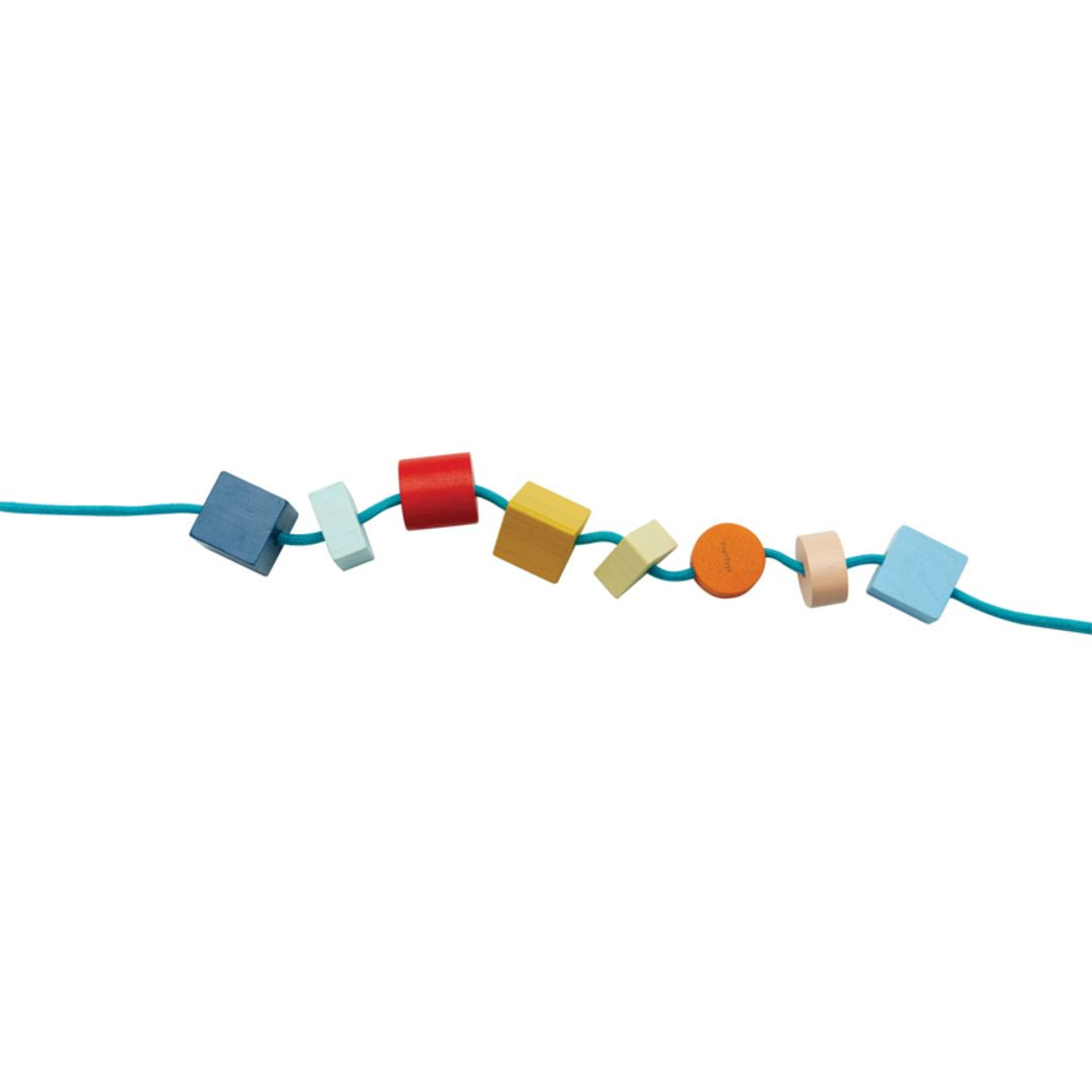 Colorful toy blocks on a string against a white background