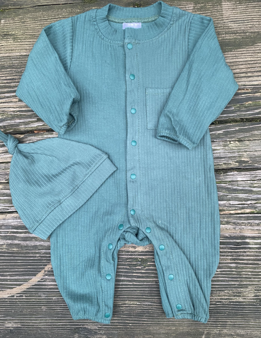 Forest green baby onesie with buttons and matching hat on a wooden surface