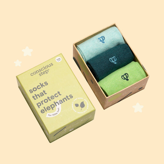 Two pairs of socks in a box with a 'conscious step' label on a beige background