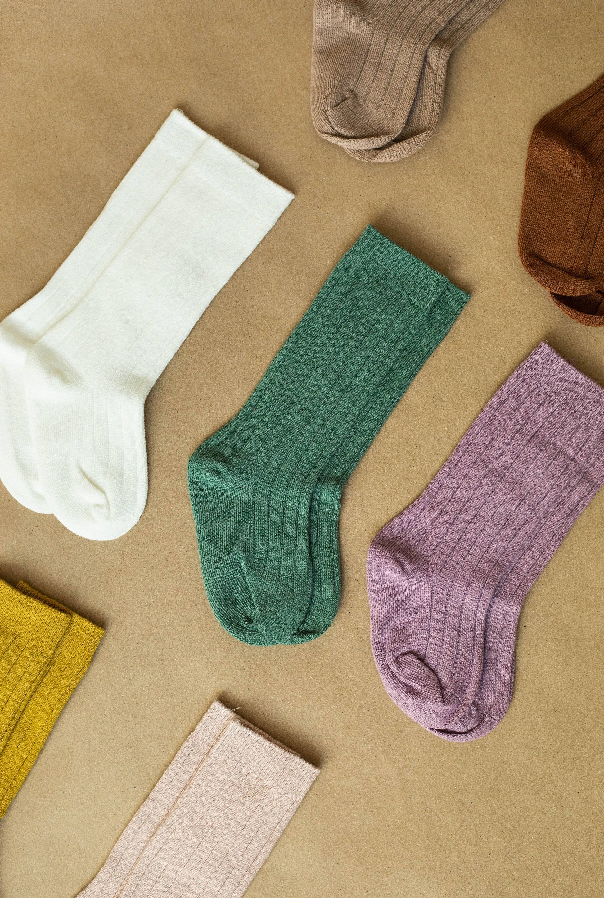 Knee high socks  1 in a row laid out on a brown back ground