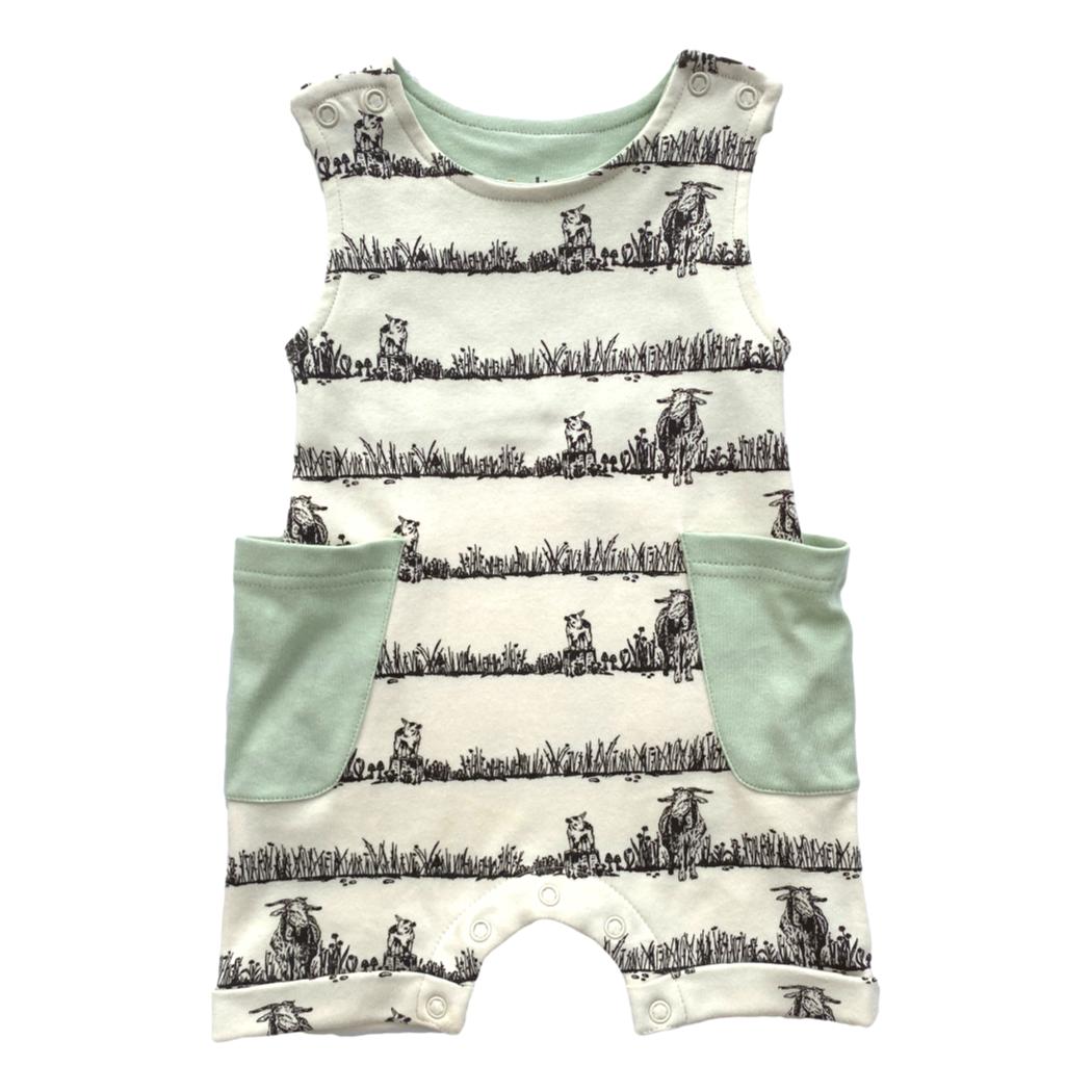 Baby romper with cow print and green accents on a white background