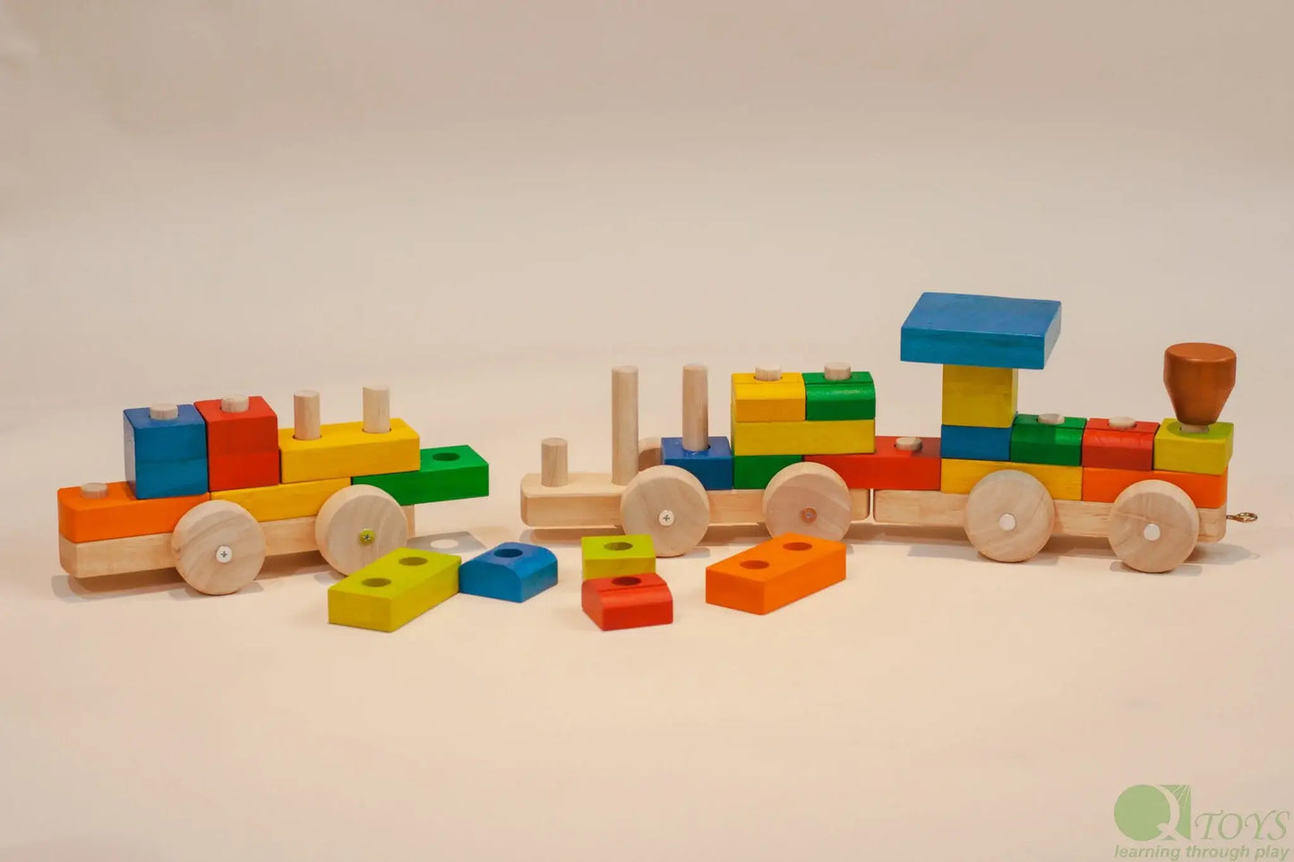 Colorful wooden toy train on a beige background