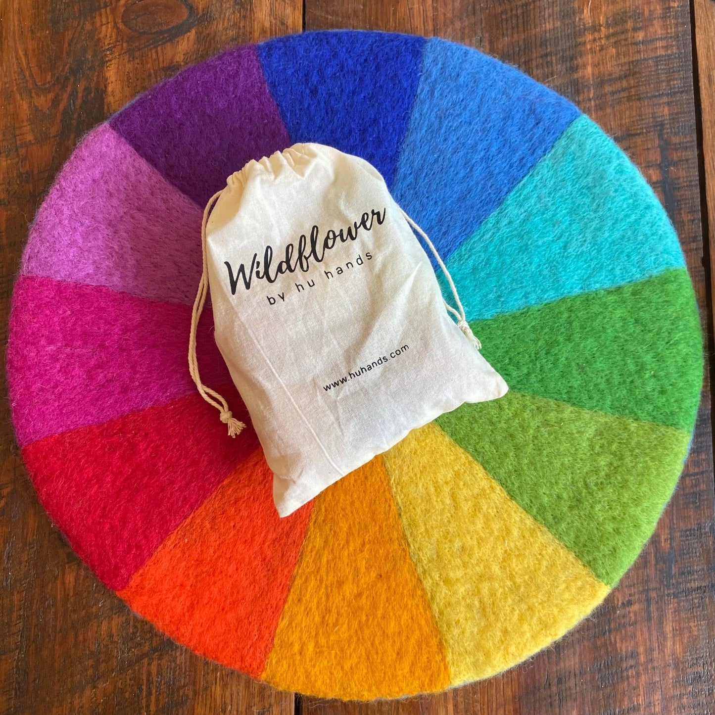 Color wheel with a drawstring bag labeled 'Wildflower by huhands' on a wooden surface