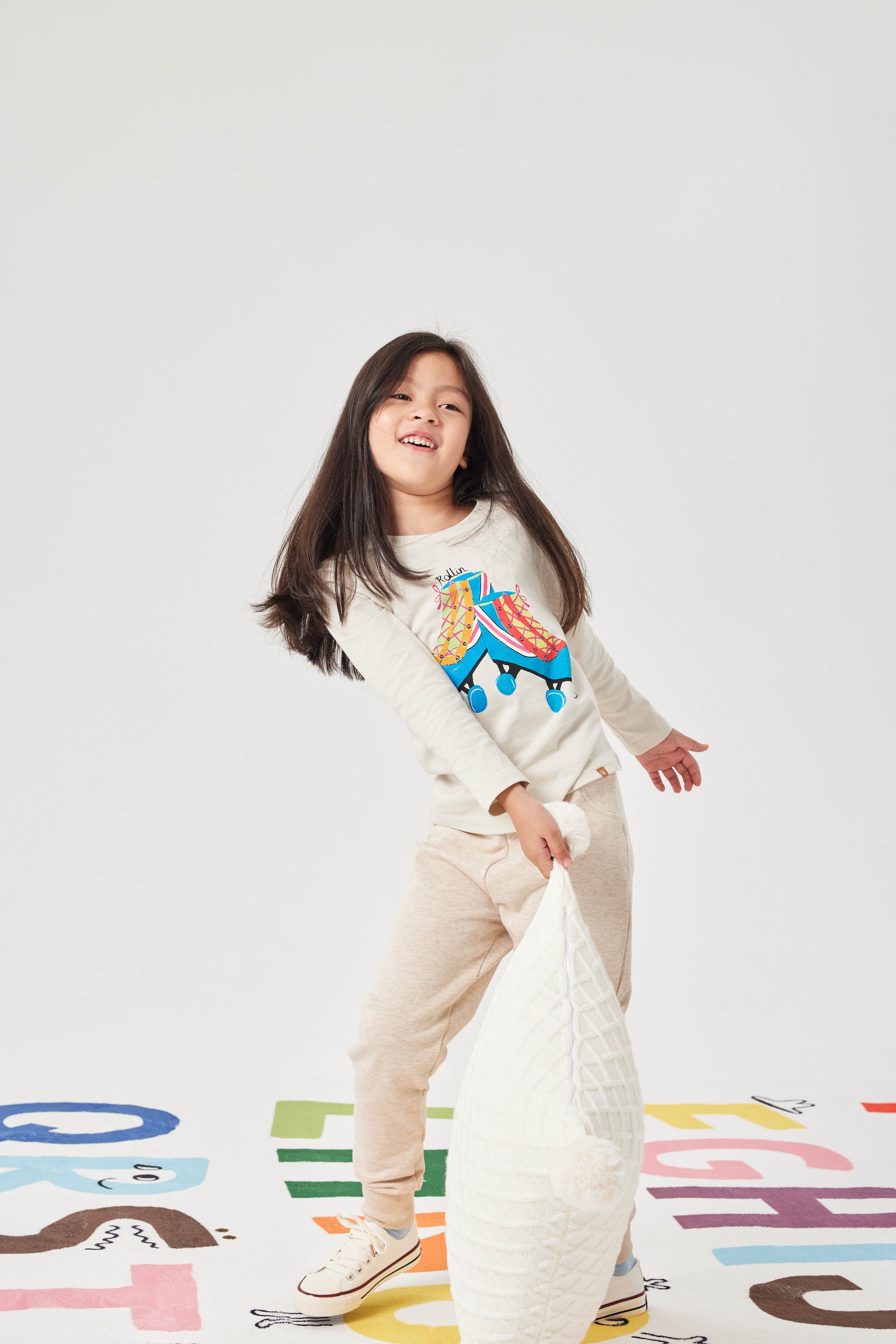 Child playing with a pillow on a colorful play mat