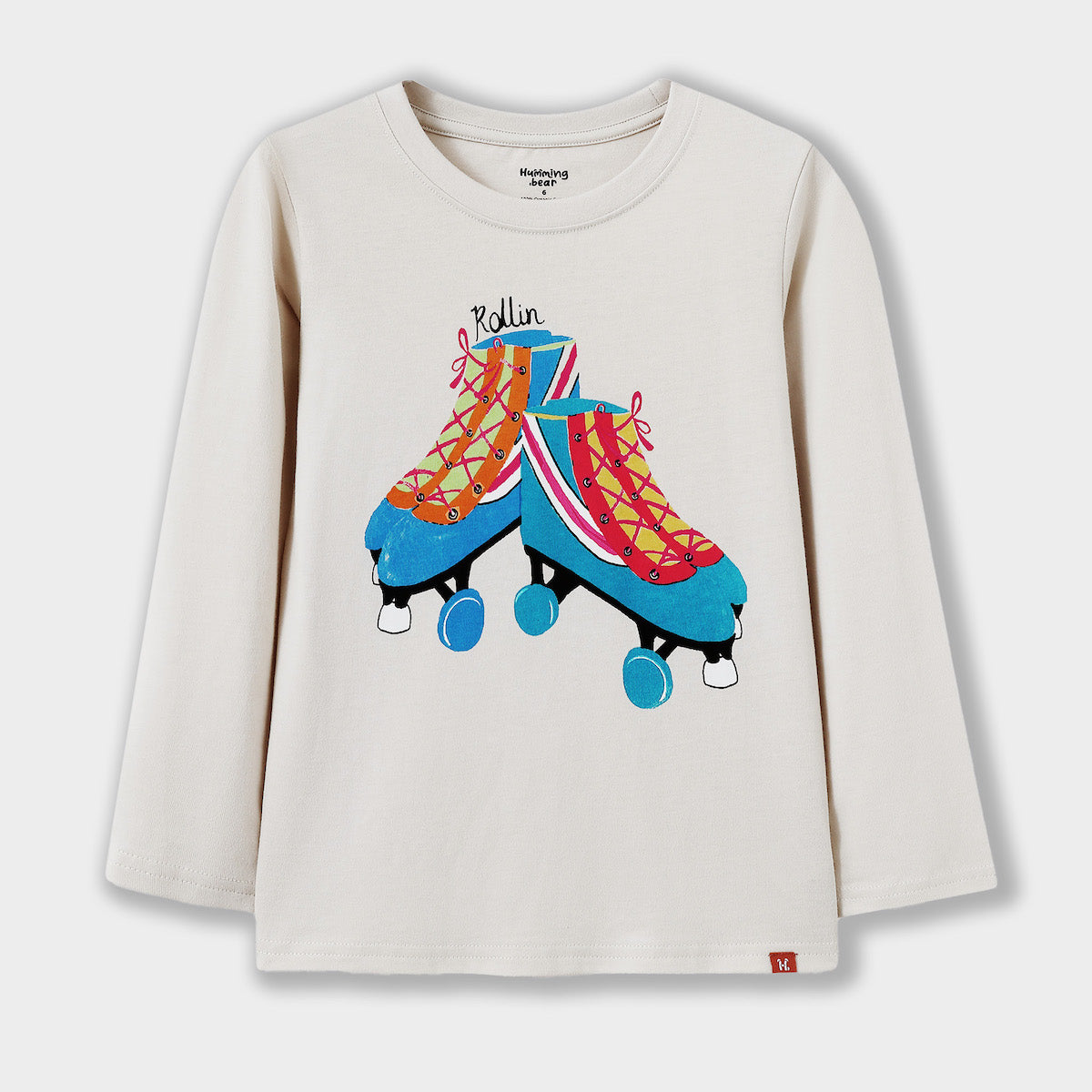 Beige long-sleeve shirt with colorful roller skates graphic on a white background