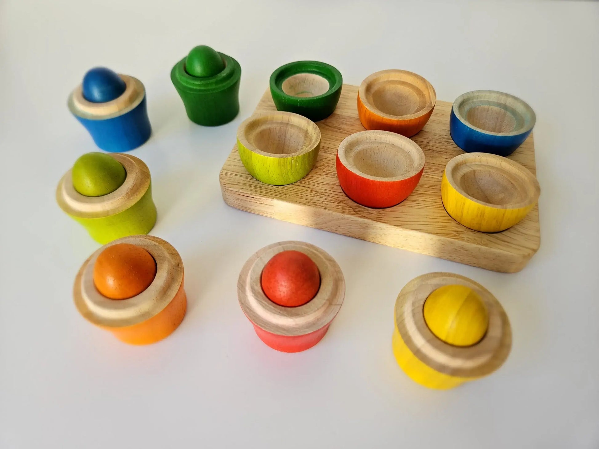 Rainbow colorful wooden sorting eggs an cups on a white back ground