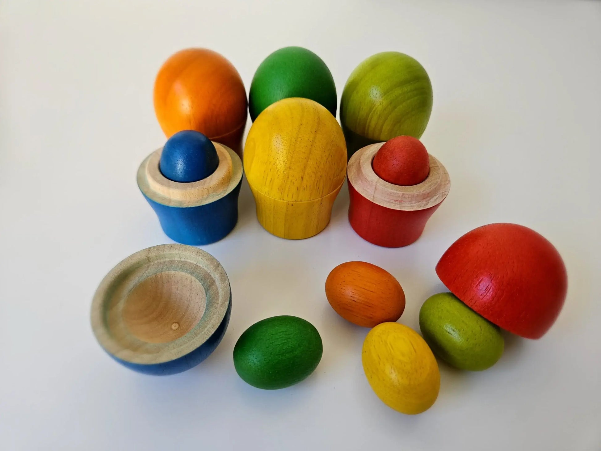 Rainbow colorful wooden sorting eggs an cups on a white back ground 