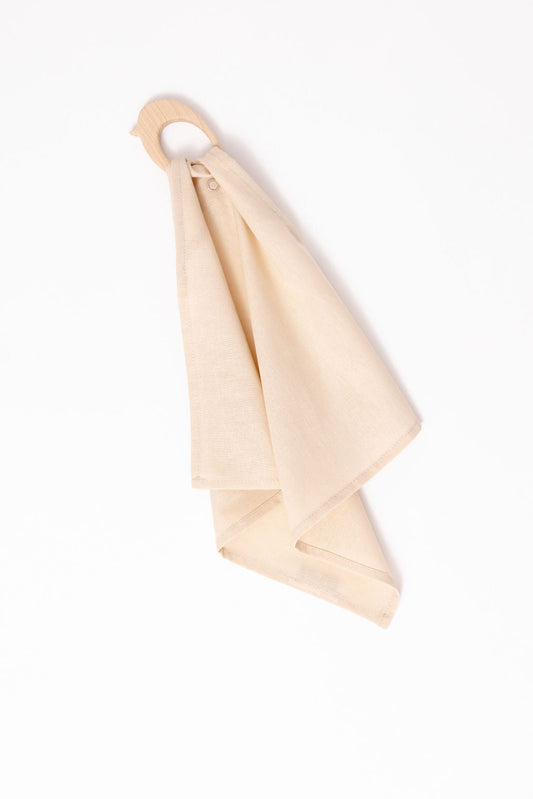 Beige towel hanging on a wooden hook against a white background