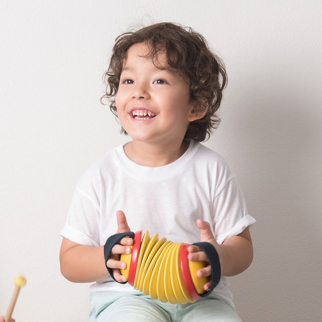 Child holding a colorful toy with a plain background
