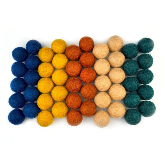 Colorful felt balls arranged in a pattern on a white background