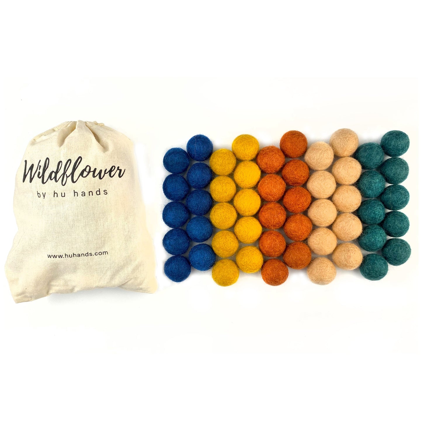 Colorful felt balls with a 'Wildflower by hu hands' bag on a white background