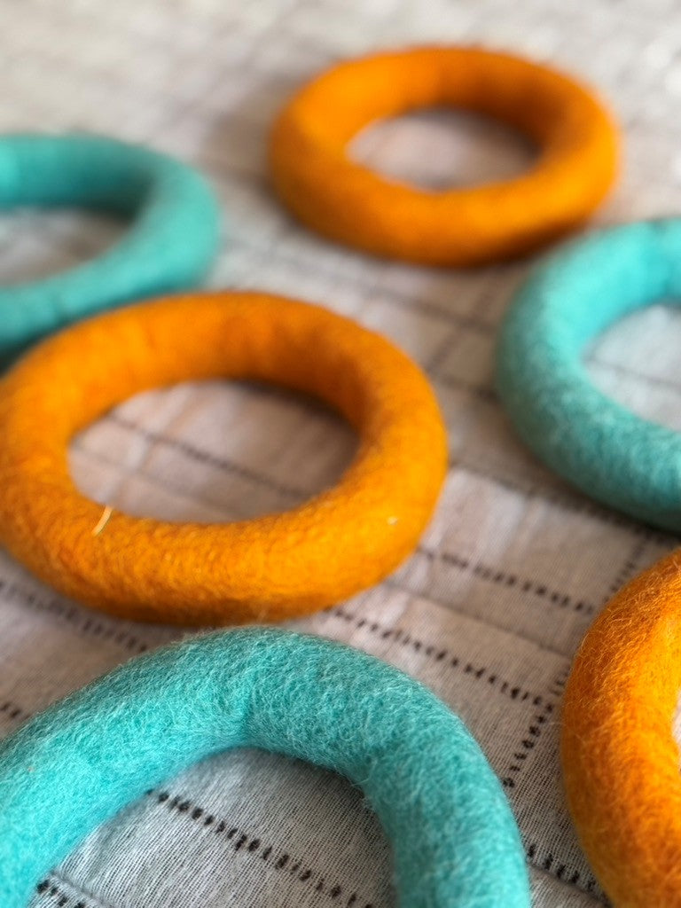 Colorful felt rings on a textured fabric background